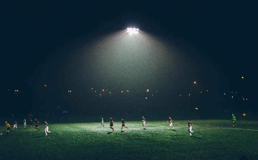 Footballers on a floodlit pitch at night