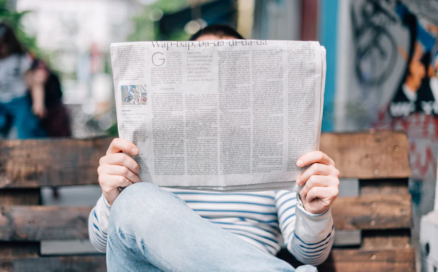 A person reading a printed newspaper